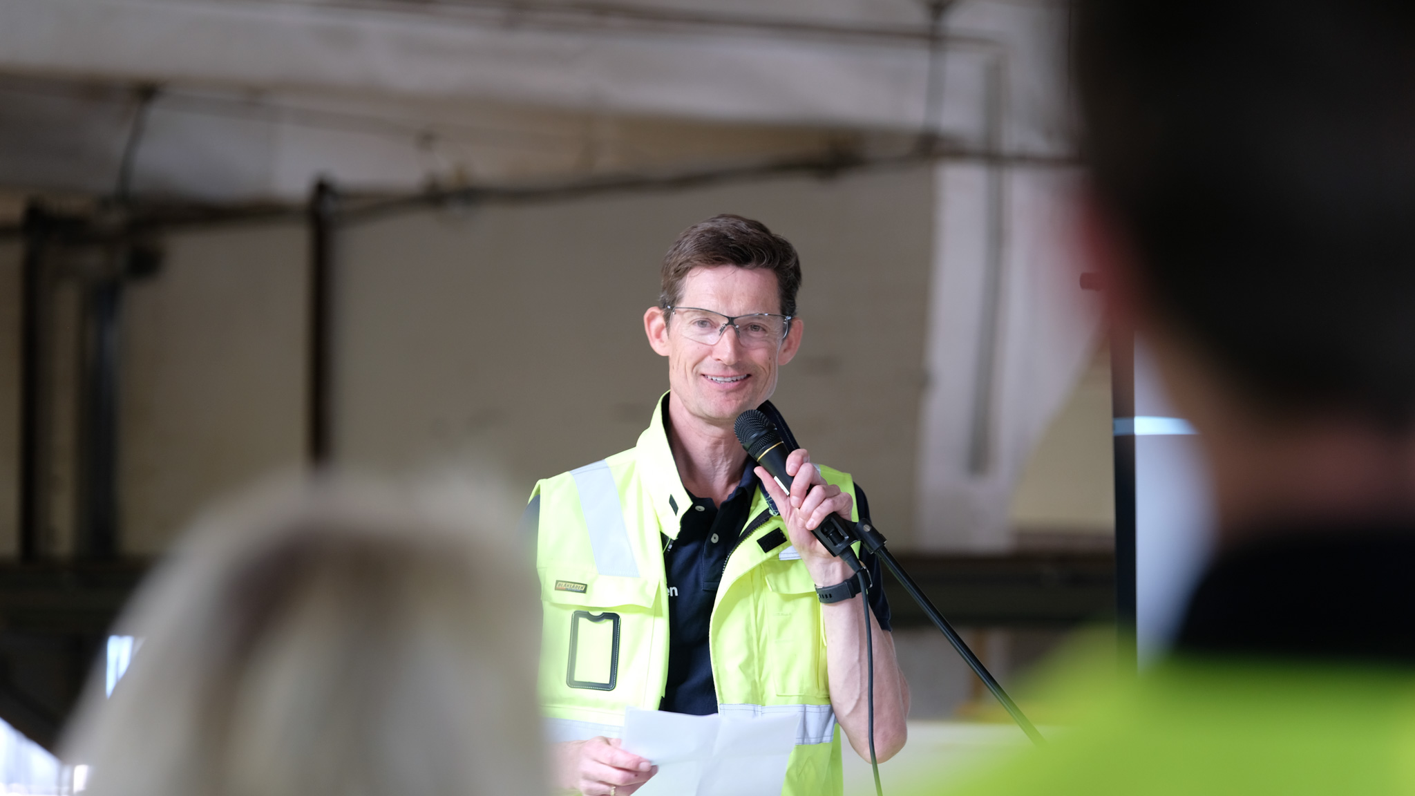 Direktør i Moelven Langmoen med mikrofon foran ansatte. Foto