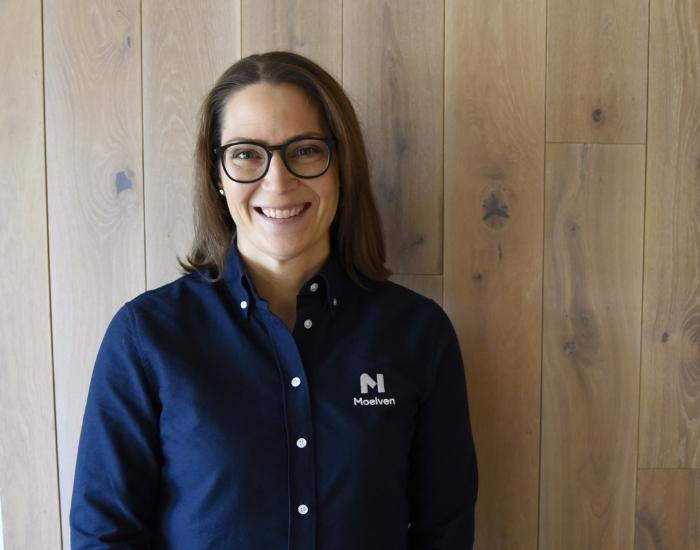 Porträtt av Therese Anhammer framför vägg i trä