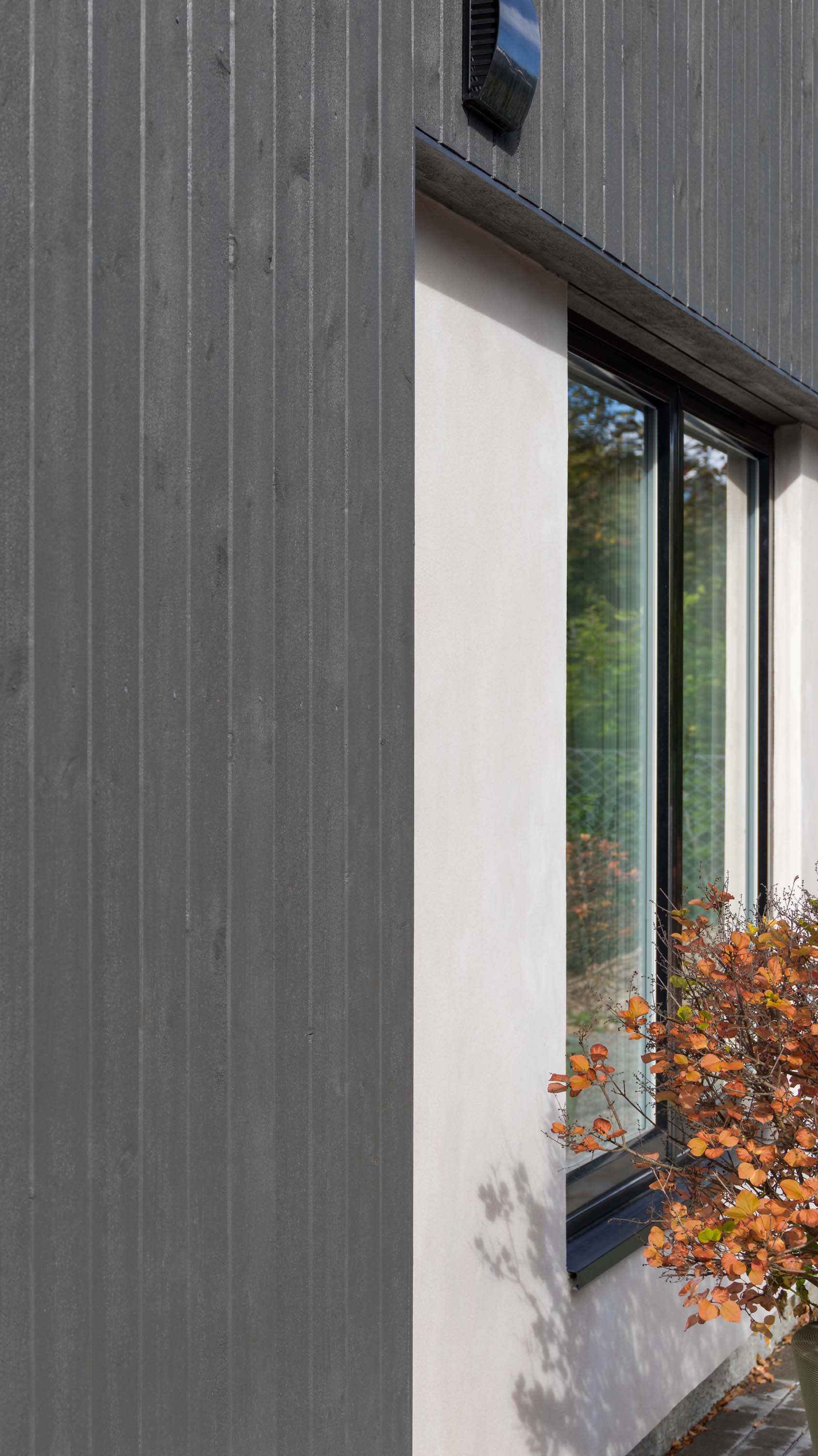 Den nye kledningen står fint til muren og de nye sorte vinduene.