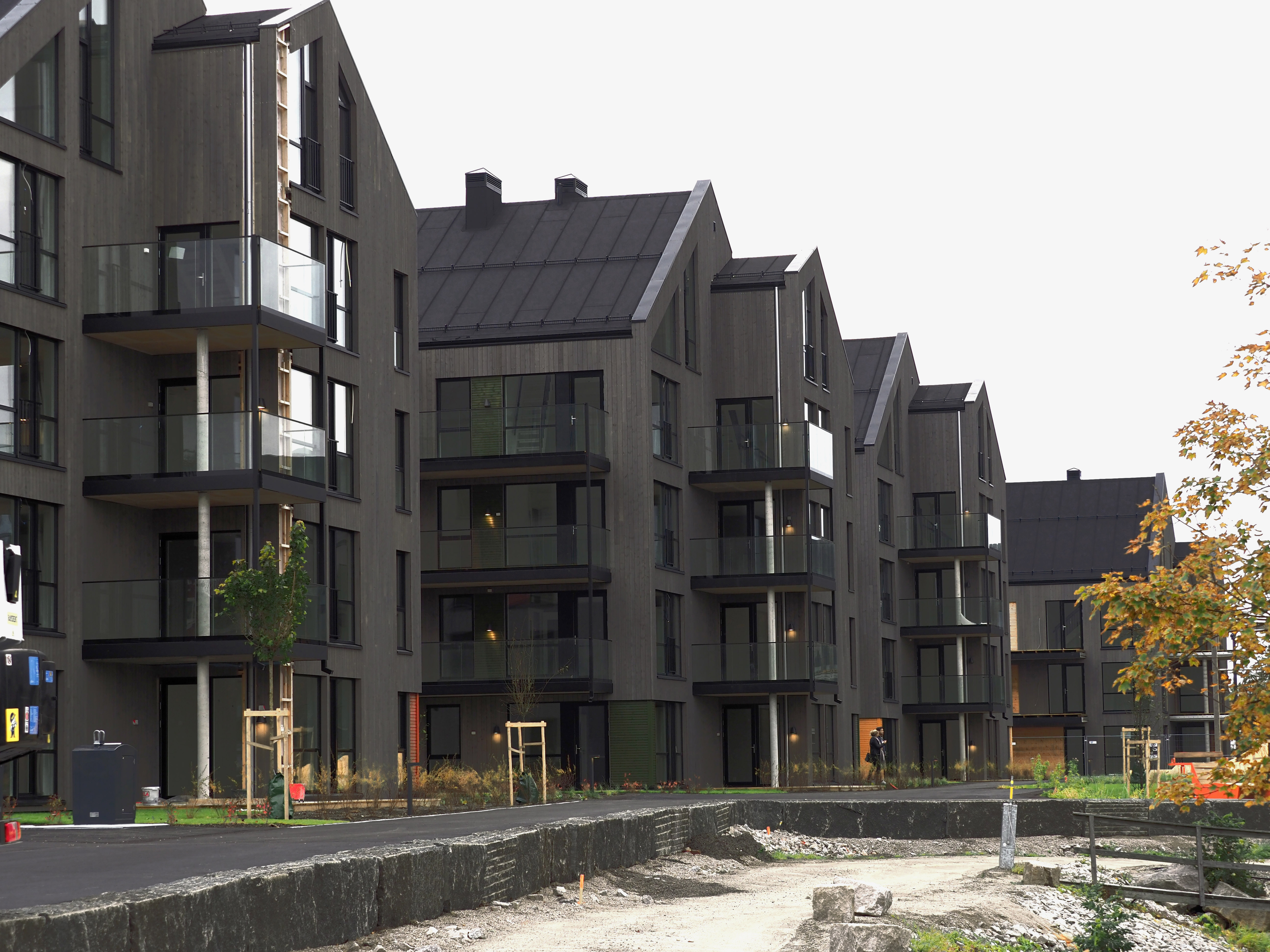 Byggning med mørk kledning av CU furu